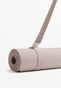 Yoga mat opgerold, gemaakt van gestructureerd grijs materiaal, vastgezet met een lichtbeige strap, met een ronde vorm en subtiel patroon.