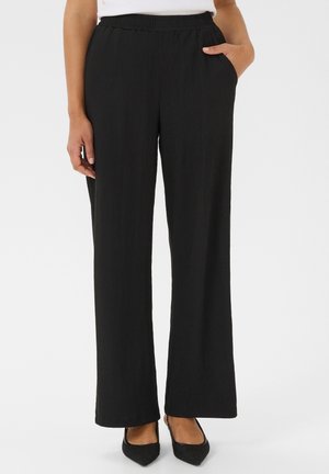 Pantalons larges noirs en tissu texturé, dotés d'une taille élastique et de poches latérales, conçus pour le confort et la facilité.