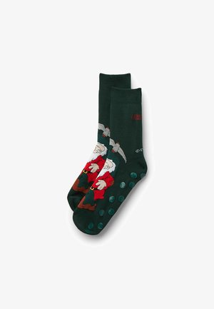 Donkergroene sokken met een bedrukt kabouterdesign in rood, wit en bruin. De zool heeft rubberen gripdots voor extra grip.