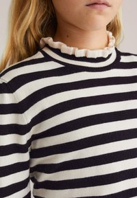 Pulover rayat în nuanțe de crem și bleumarin, cu un guler ondulat, cu nervuri. Textură moale, tricotată, cu dungi orizontale alternative.