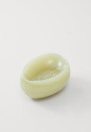 Przeźroczysta zielonkawa miska z onyksu o gładkich, zaokrąglonych krawędziach i płytkim wnętrzu. Wyraźne jasne żyłkowanie i drobne niedoskonałości podkreślają teksturę.