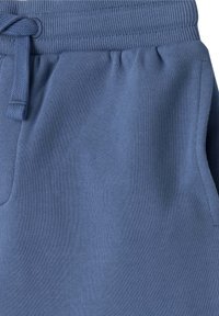 Svetle modré tepláky vyrobené z měkké bavlněné směsi. Mají elastický pas se šňůrkou a boční kapsy.