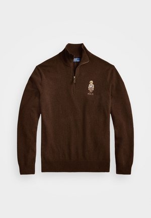 Bruine trui met ritssluiting gemaakt van zachte stof, voorzien van een klein geborduurd logo op de linkerborst. Klassieke pasvorm met geribde boorden en onderrand.