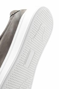 Scarpa slip-on in suede grigio con suola in gomma bianca, caratterizzata da un motivo testurizzato e un accento rettangolare sul lato.