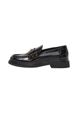 Mocassin en cuir noir brillant avec talon bas, clous dorés décoratifs sur la bride et coutures détaillées sur l’avant et les côtés.
