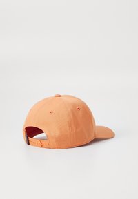 Casquette de baseball orange avec un pic rigide, texture en tissu, sangle réglable à l'arrière et trous de ventilation. Design minimaliste.