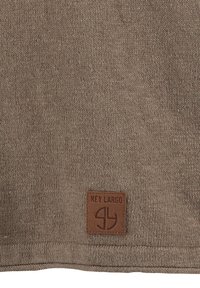 Braun gestrickter Stoff mit einer strukturierten Oberfläche. Ein rechteckiges Lederpatch zeigt die Marke "Key Largo" und ein Logosymbol.