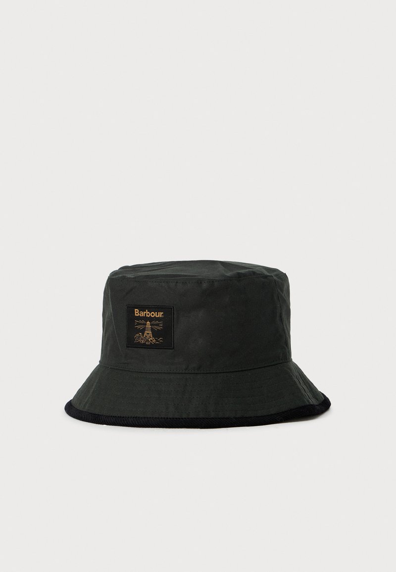 Černý klobouk s krempou se malou obdélníkovou nášivkou s majákem a názvem značky "Barbour" v zlatých tónech.