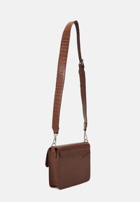 Brun skuldertaske i krokotekstur af læder med fladt design, justerbar rem og metalhardware-detaljer. Klaplukning foran.