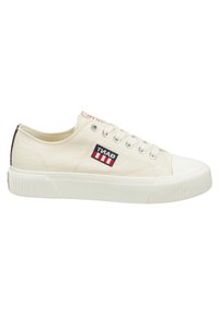Zapatillas de lona en color blanco roto con una superficie texturizada, que presentan un parche con logo y un detalle en el talón de color marrón contrastante. Suela de goma con agarre con patrón.