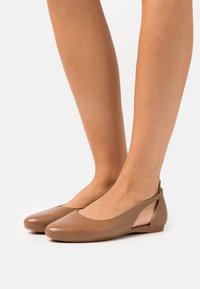 Brązowe skórzane baletki z zaokrąglonym noskiem, otwartym tyłem i gładką fakturą. Smukła forma z minimalnymi szwami i bez ozdób.