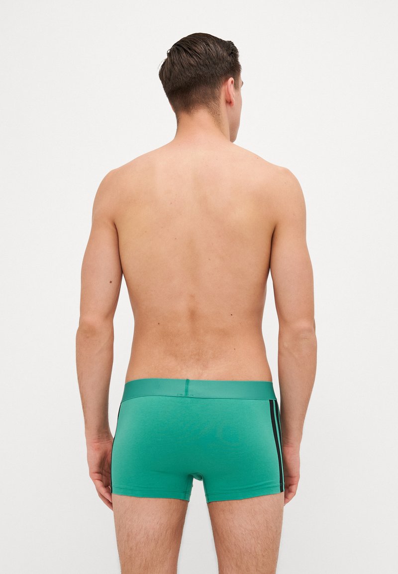 Grüne Boxershorts mit glatter Textur, die an den Seiten mit einem kontrastierenden schwarzen Streifen versehen sind und einen bequemen Bund haben.