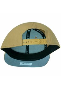 Baseballkappe mit einem beigefarbenen Oberteil, grauem Schirm und schwarzem Unterrand. Verstellbarer Riemen hinten; Innenseite mit Mesh und Branding ausgekleidet.