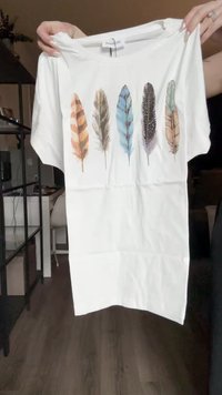 Tricou alb cu cinci pene ilustrate în culori și modele diferite. Mâneci scurte și un gât clasic în formă de cerc.