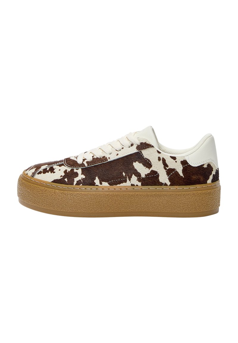 Sneakers cu un model de vacă alb-negru și maro, cu un profil scăzut, un upper texturat, vârful rotund și o talpă din cauciuc caramel. Dispun de șirete plate și accente de cusătură.