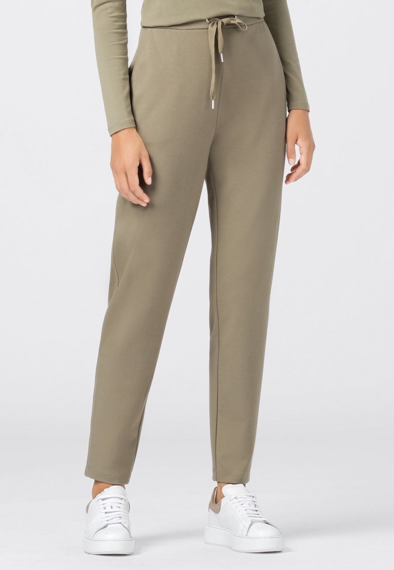 Olivgrüne Sweatpants mit elastischem Bund und verstellbarem Kordelzug, ausgestattet mit Seitentaschen und schmal zulaufenden Hosenbeinen.