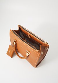 Borsa tote in pelle beige con doppi manici, chiusura superiore con zip e dettagli in hardware dorato. Include una piccola pochette coordinata. L'interno è foderato in tessuto.