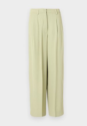 Gaiši bēšas augsta vidukļa plašas bikses ar krokojumu, jostas cilpām un priekšpuses rāvējslēdzēja aizdari.