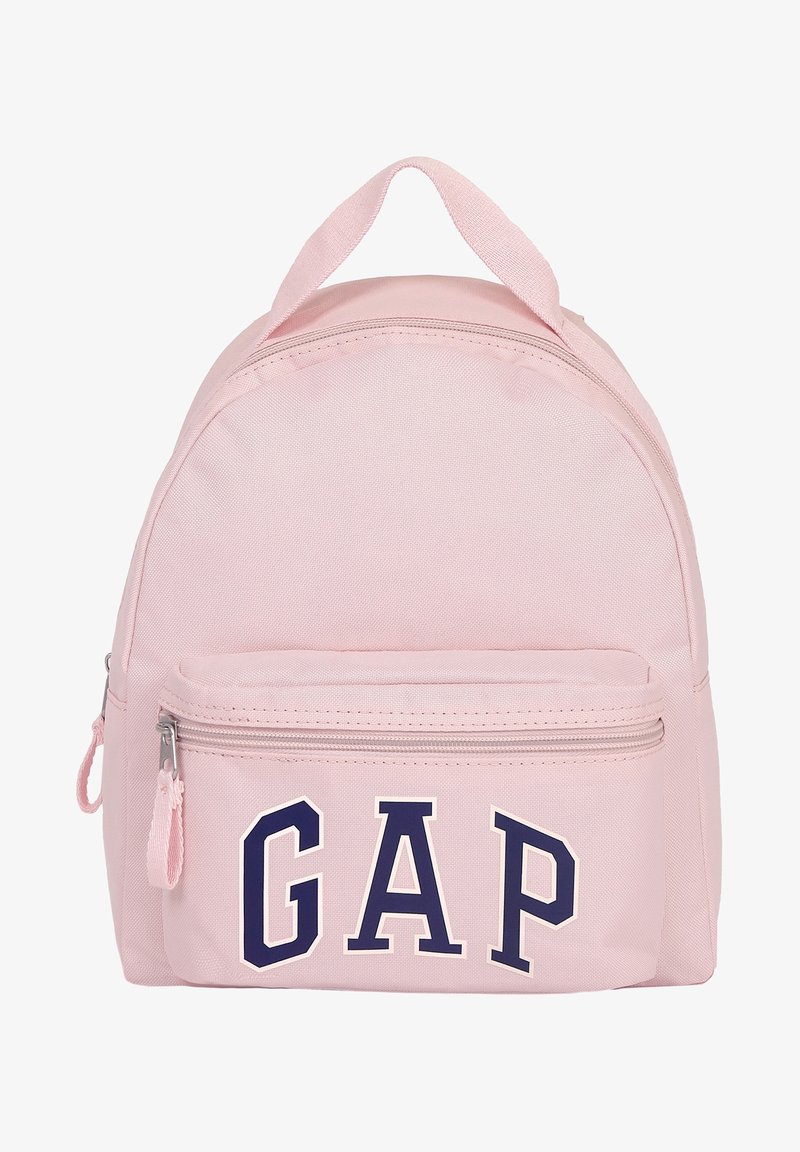 Petit sac à dos rose clair avec poche avant zippée et grandes lettres bleu marine "GAP" sur la poche.