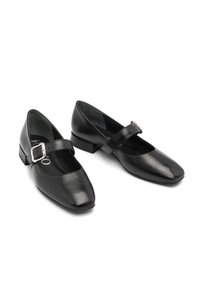 Zapatos de cuero negro con punta cuadrada, tacón bajo en bloque y una sola correa con un detalle de hebilla plateada. Textura lisa y pulida.