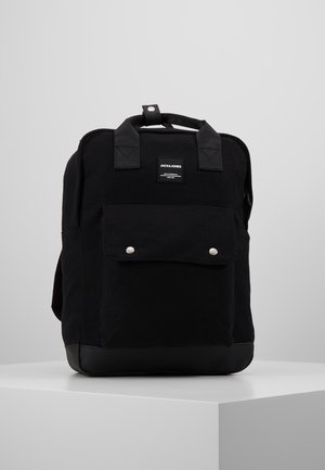 Czarny prostokątny plecak z przednią kieszenią zabezpieczoną dwoma srebrnymi guzikami, podwójnymi uchwytami oraz małą etykietą marki umieszczoną na środku u góry.