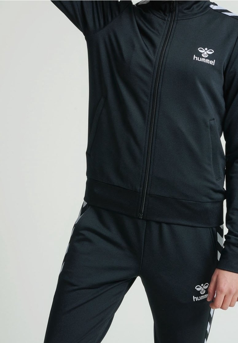 Black athletic tracksuit made of smooth fabric, featuring a zippered jacket with logo and striped accents on pants. Waistband is elastic.