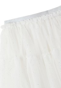 Gonna bianca in tulle con volant a strati e glitter argento sparsi. La vita elastica argentata aggiunge un contrasto decorativo. Tessuto morbido e trasparente.