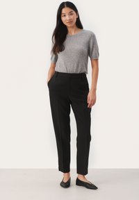Gray knit short-sleeve top paired with black tailored pants. Pants feature side pockets and a straight-leg cut. Black flats complete the outfit.
