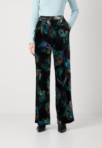 Pantaloni largi din catifea neagră cu un model colorat de frunze, închidere cu buton frontal, buzunare și o textură netedă.