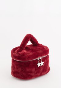 Rød taske i kunstpels med rund form, lynlås og top-håndtag. Udstyret med sølvstjernedekorationer. Blød tekstur og fyldig udseende.