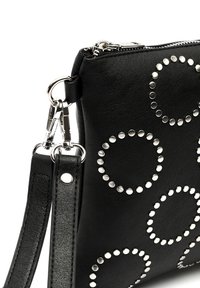 Borsa a mano nera in pelle con borchie circolari argentate, chiusura a zip e tracolla regolabile. Finitura testurizzata con design minimalista.