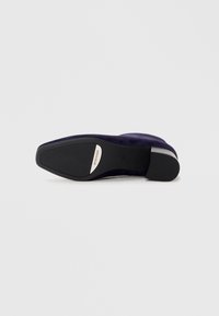 Navy suede men's loafer shown from the sole, with black rubber outsole and silver logo plate reading "Peter Kaiser."