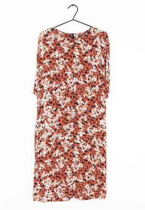 Kjole med blomsterprint med orange, hvide og sorte blomster, hængende på en sort bøjle mod en hvid baggrund.