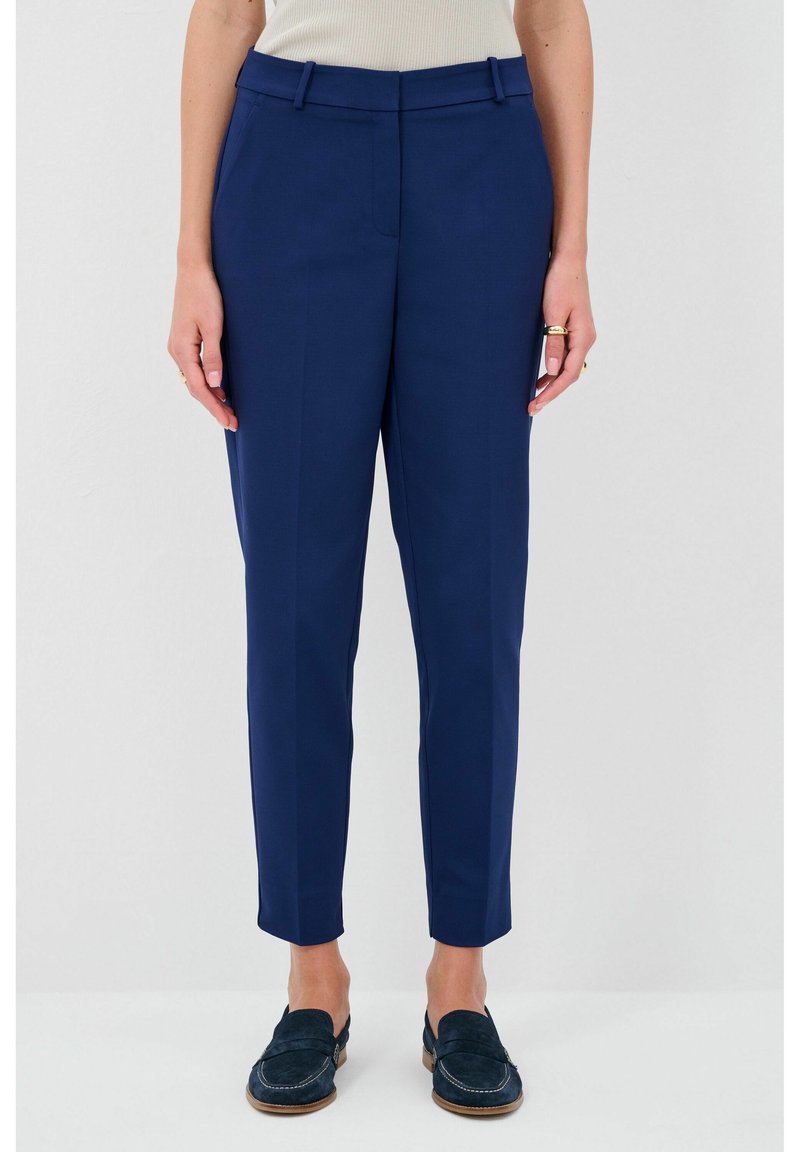 Marineblauwe op maat gemaakte broek met een soepele textuur, voorzien van een middelhoge taille en taps toe lopende pijpen. Riemlussen en subtiele fraaie plooien zichtbaar.