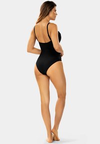Czarny jednoczęściowy strój kąpielowy z regulowanymi ramiączkami, marszczoną teksturą z przodu i średnio wyciętymi nogawkami. Gładkie wykończenie materiału.