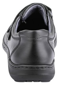 Black leather shoe with a rounded toe, padded collar, and textured surface. Features visible stitching and a sturdy rubber sole.