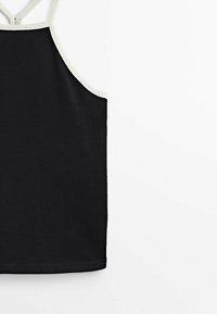 Top noir sans manches avec un bord blanc le long de l'encolure et des bretelles, posé à plat sur un fond blanc.