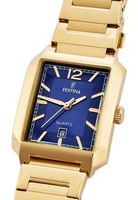 Reloj de cuarzo en tono dorado con cara cuadrada, esfera azul, marcadores de horas dorados y display de fecha. Presenta una pulsera de eslabones metálicos y una corona.
