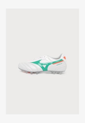 Chaussure de football blanche avec des accents verts et orange, des crampons sous la semelle et le mot Morelia sur le côté.