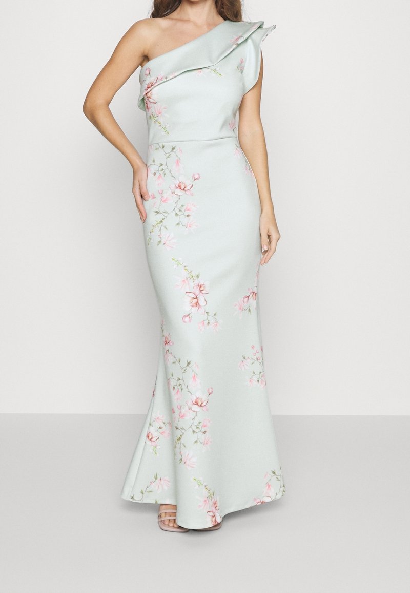 Yhden olkapään, muotoiltu mekko vaaleanmintunvärisenä, jossa on vaaleanpunaisia ja vihreitä kukkakuoseja. Silkkinen kangas, levenevä helma, yksityiskohtainen ruffla olkapäällä.