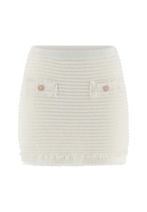White knit skirt with a textured, ribbed design, featuring two front pockets with decorative buttons and a fringed hem.
