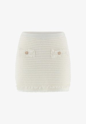 Jupe en tricot blanc avec un design texturé et à côtes, dotée de deux poches avant avec des boutons décoratifs et un ourlet à franges.