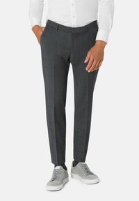 Grijze geruite broeken met een gestructureerde afwerking, voorzien van een slim fit, riemlussen en zijzakken, gecombineerd met lichtgrijze sneakers.