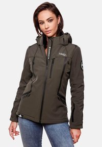 Woman wearing a dark green hooded softshell jacket with zippered pockets, standing against a plain light background.