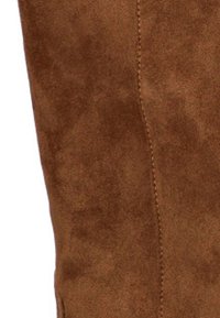 Bota de ante marrón con una textura suave, forma ajustada y detalles de costura sutiles a lo largo del costado. Sin hardware visible ni patrones.