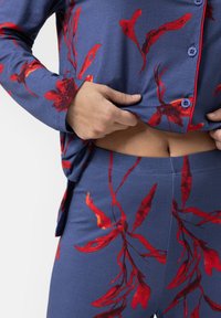 Navyblaues Lounge-Set mit Blumenmuster und roten botanischen Drucken; Oberteil mit Knöpfen, langen Ärmeln und elastischem Bund an der Hose.