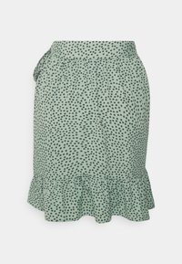 Falda de tela verde con un dobladillo fruncido, adornada con lunares negros. Presenta una cinturilla elástica y un diseño gathered.