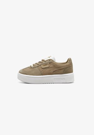 Tan ruskinds sneakers med en hvid gummisåler. Har en rund tå, snørebånd foran og gyldne logo detaljer på siden og på tungen.