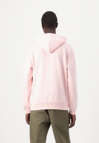 Sudadera con capucha de color rosa claro, de corte relajado, con puños y dobladillo acanalados. Fabricada en suave algodón, diseñada para brindar comodidad y facilidad de uso.