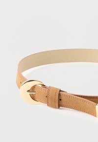 Ταν σουέτ ζώνη με λείο χρυσό κυκλικό κούμπωμα. Διαθέτει κομψό σχέδιο και ρυθμιζόμενο λουρί με τρύπες για σφίξιμο.